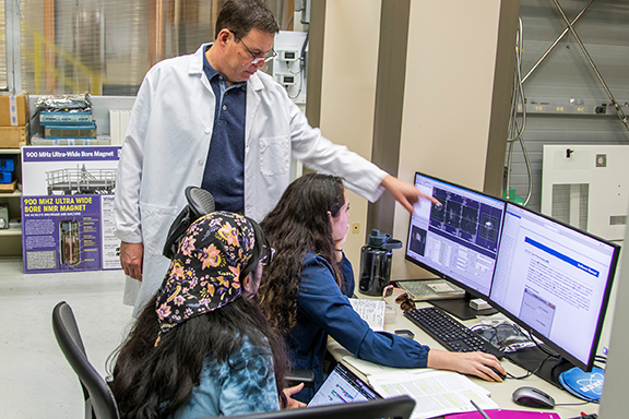 Samuel Grant, top, professor and postdoctoral fellow director in Chemical and Biomedical Engineering at the FAMU-FSU College of Engineering, works with, from left, graduate students Jamini Bhagu and Dayna Richter at the 900-megahertz magnet at the National High Magnetic Field Laboratory in Tallahassee, Florida. (Mark Wallheiser/FAMU-FSU College of Engineering)