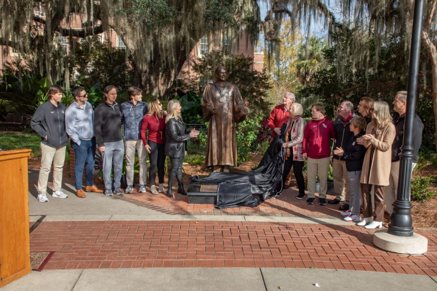 FSU President Emeritus John Thrasher unveils his statue with family members after a dedication ceremony on Saturday, Nov. 19, 2022, at Westcott Plaza. (FSU Photography Services)