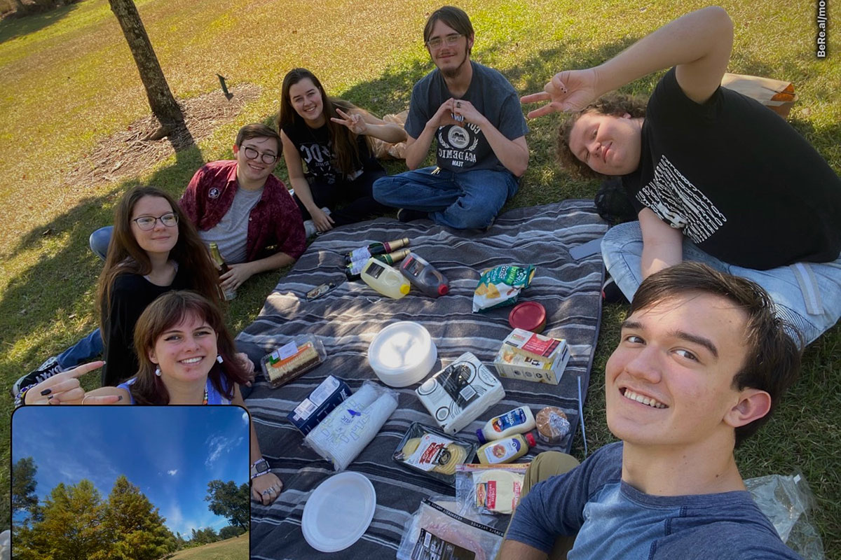 A group of friends from the Exploration & Discovery LLC picnic and pose for the popular photo-sharing application BeReal.