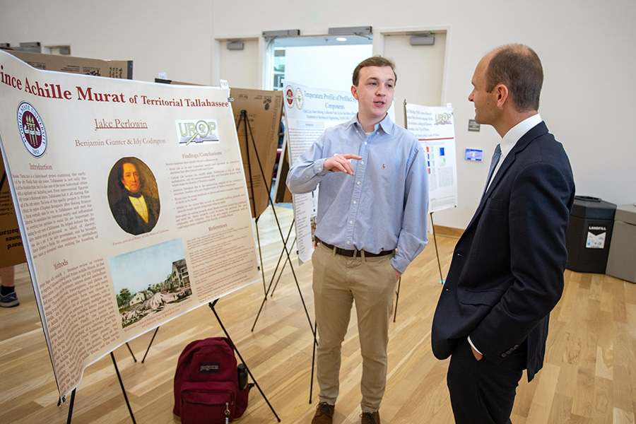 Associate Provost and Dean of Undergraduate Studies Joe O'Shea visits with a student researcher presenting at the 23rd annual Undergraduate Research Symposium in the Student Union ballrooms April 6, 2023. (FSU Photography Services)
