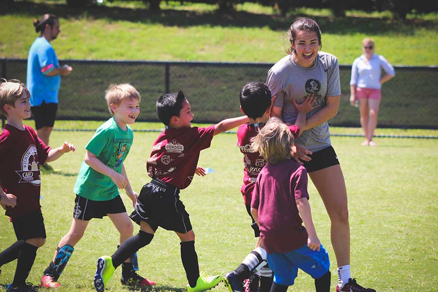 Lauren Flynn, a midfielder on the FSU Soccer team shares a laugh with participants in the 2022 Kickin' It for Autism event.