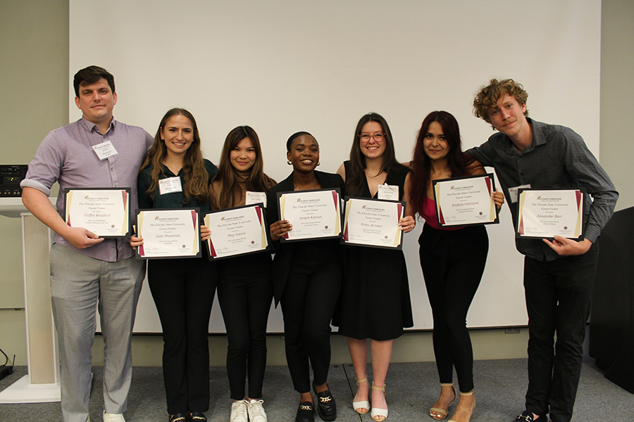 Category and overall winners for the Student Employee of the Year Award, Griffin Bradford, Gabi Mastando, Jayremay Garcia, Emem Kierian, Michaley deLeon, Kristina Feliciano, Alexandre Barr, stand together with certificates in hand.