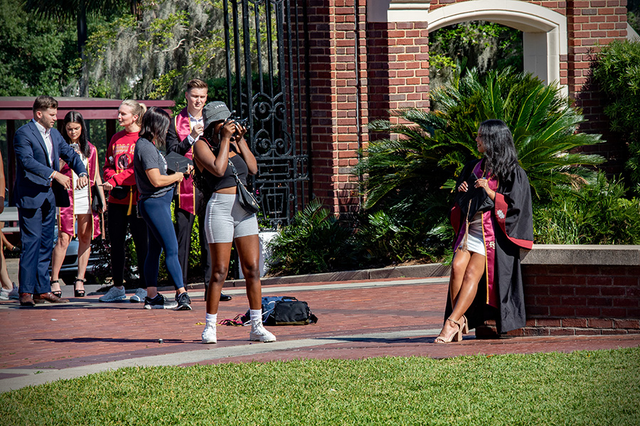 An FSU graduate poses for photos on Westcott Plaza before the 2023 spring commencement ceremonies May 6, 2023. (FSU Photography Services)