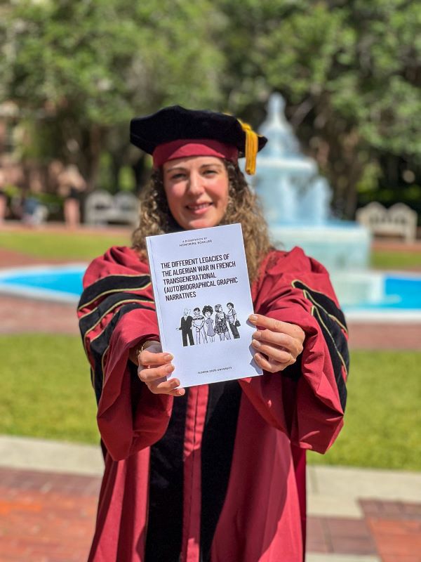 Honorine Rouiller, an international student from France, poses with her dissertation "The Different Legacies of the Algerian War in French Transgenerational (Auto)biographical Graphic Narratives." She earned her doctorate in Contemporary French and Francophone Studies this spring.