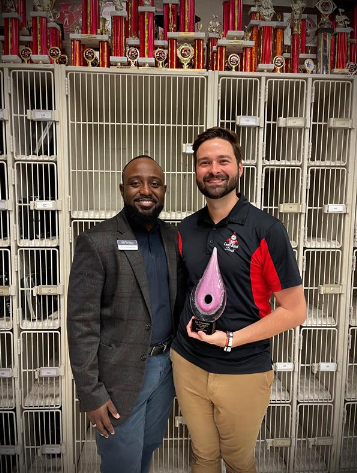 (From left) VyStar representative Miron Richardson presenting Lee Commander with the Art Advocate Award in the Leon High School Band room.