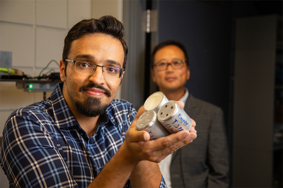 FAMU-FSU College of Engineering doctoral candidate Farhad Farzaneh holds examples of the tubes he and Professor Sungmoon Jung, right, designed to protect electric vehicle batteries from overheating and impacts. (Mark Wallheiser/FAMU-FSU College of Engineering)