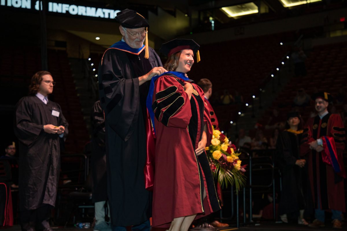 A Florida State University faculty member hoods a doctoral graduate the summer doctoral hooding ceremony Friday, Aug. 4, 2023, at the Donald L. Tucker Civic Center. (FSU Photography)