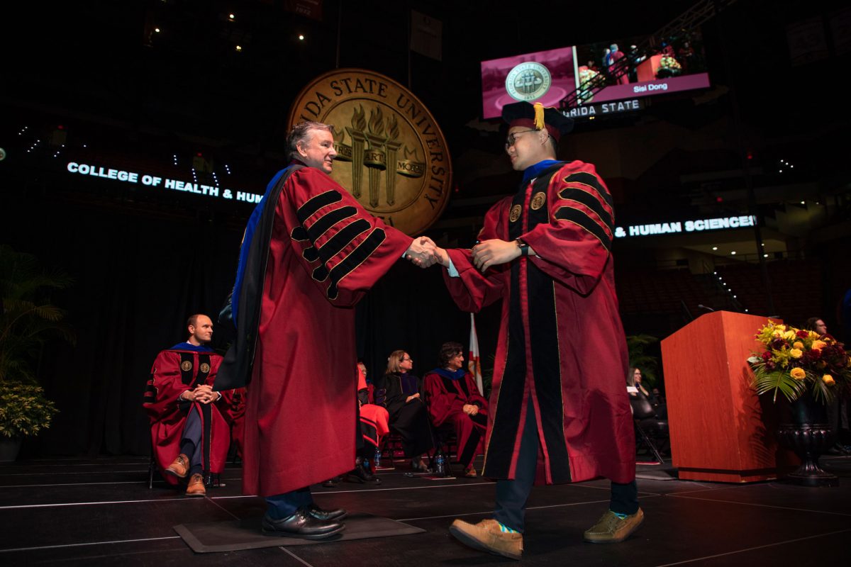 A Florida State University faculty hoods a doctoral graduate the summer doctoral hooding ceremony Friday, Aug. 4, 2023, at the Donald L. Tucker Civic Center. (FSU Photography)