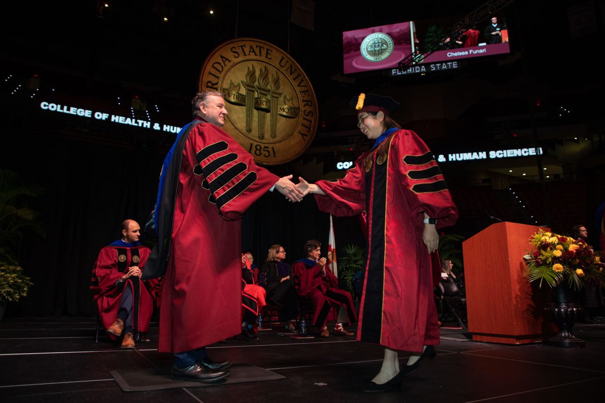 Florida State University President Richard McCullough congratulates a graduate during the summer doctoral hooding ceremony Friday, Aug. 4, 2023, at the Donald L. Tucker Civic Center. (FSU Photography)