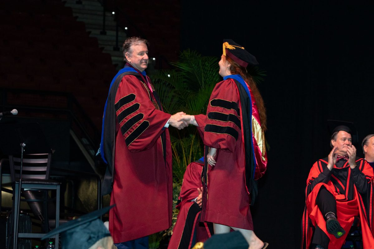 Florida State University President Richard McCullough congratulates a graduate to the university’s summer doctoral hooding ceremony Friday, Aug. 4, 2023, at the Donald L. Tucker Civic Center. (FSU Photography)
