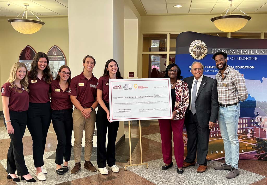 Students from FSU Dance Marathon present a check to FSU College of Medicine Interim Dean Dr. Alma Littles, third from right, and Dr. Rashmin Savani, second from right, chair of the UF College of Medicine Department of Pediatrics and physician-in-chief for UF Health Shands Children's Hospital. Also pictured is second-year FSU medical student David Labissiere, far right, president of the Pediatric Interest Group.