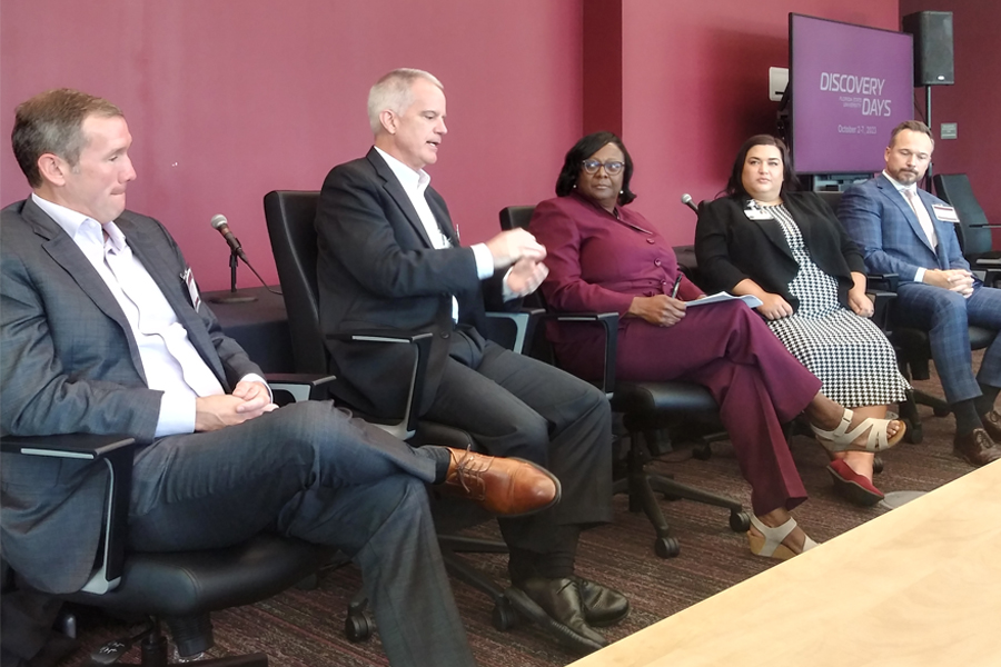 Second from left, Dr. Dean Watson, Chief Integration Officer at Tallahassee Memorial HealthCare, speaking at the UIDP Tallahassee Regional Assembly, held in conjunction with FSU Discovery Days. Joining him are, from left, Mike Boblitz, CEO of Tallahassee Orthopedic Clinic; Dr. Alma Littles, dean of the FSU College of Medicine; Lacy Phillips, Vice president of Quality and Patient Safety at HCA; and Brian Hultgren, Vice Chair of Research at Mayo Clinic in Florida. (Photo by: Bill Wellock/Florida State University)