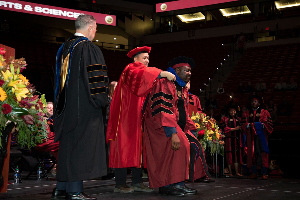 A Florida State University faculty member hoods a doctoral graduate the fall doctoral hooding ceremony Friday, Dec. 15, 2023, at the Donald L. Tucker Civic Center. (FSU Photography Services)