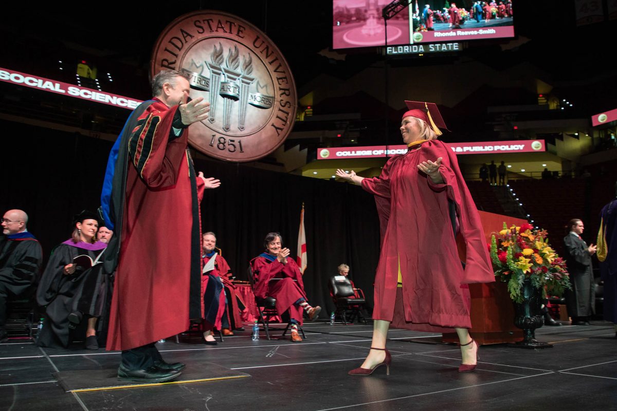 President Richard McCullough congratulates a graduate during commencement Friday, Dec. 15, 2023, at the Donald L. Tucker Civic Center. (FSU Photography Services)