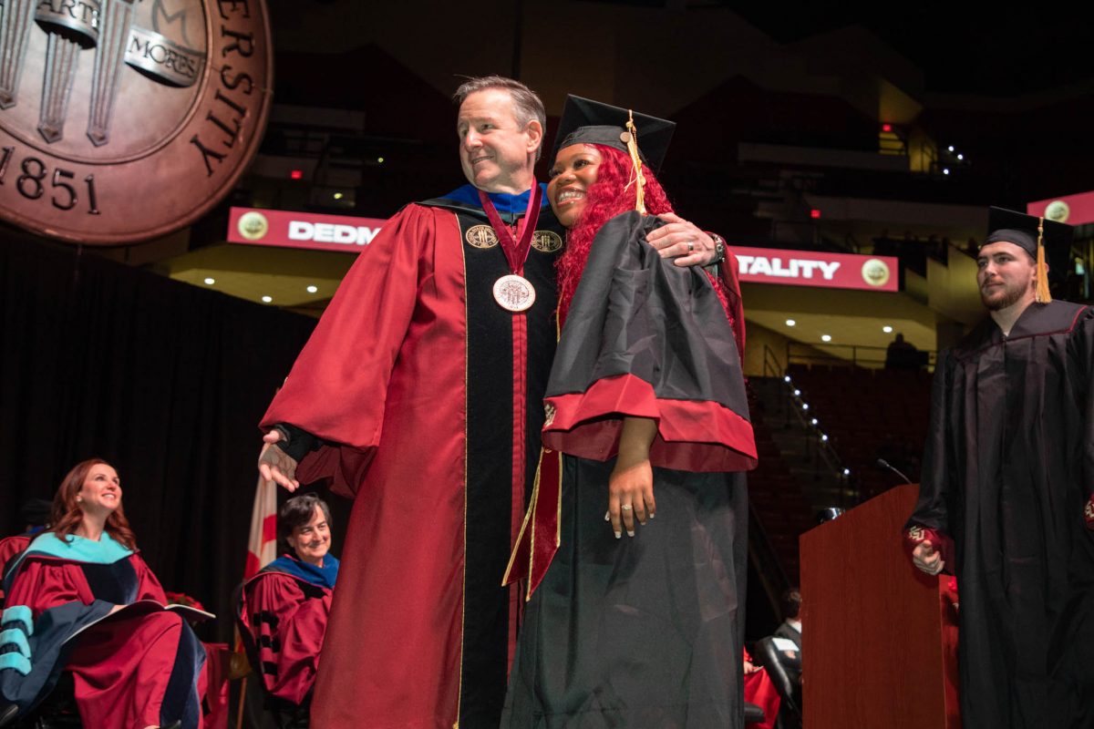 President Richard McCullough congratulates a graduate during commencement Friday, Dec. 15, 2023, at the Donald L. Tucker Civic Center. (FSU Photography Services)