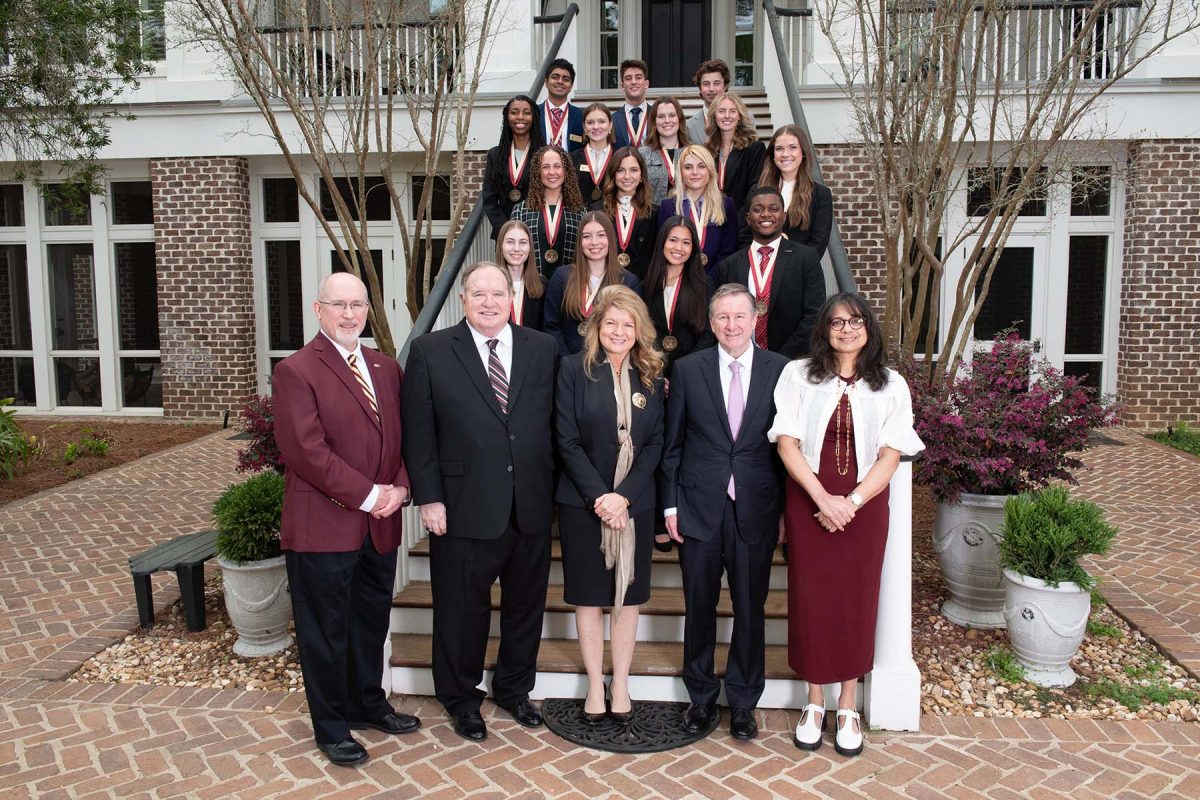 From left, College of Business Dean Michael Hartline, James and Martha Seneff, FSU President Richard McCullough and First Lady Jai Vartikar pose with the 2023 class of Seneff Scholars on the back steps of the FSU President’s House. Two scholars were unable to attend Friday’s ceremony. Photo by Kallen Lunt/FSU College of Business