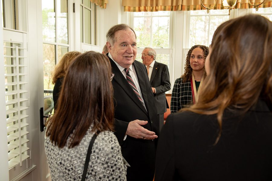 James M. Seneff, the benefactor and namesake of the James M. Seneff Honors Program, talks with students and other attendees after Friday’s medaling ceremony at the FSU President’s House. (Kallen Lunt/FSU College of Business)