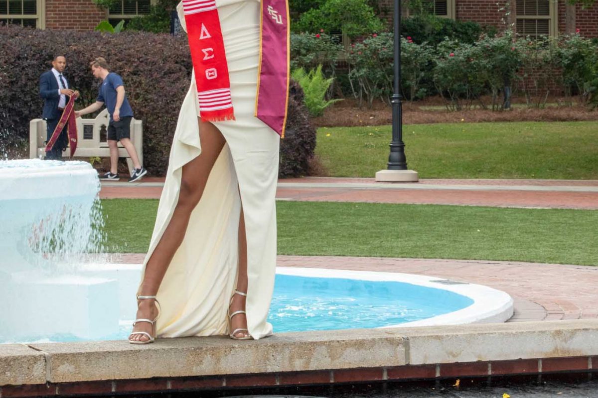 A graduate poses for photos in front of Westcott Fountain on May 1, 2024. (FSU Photography)