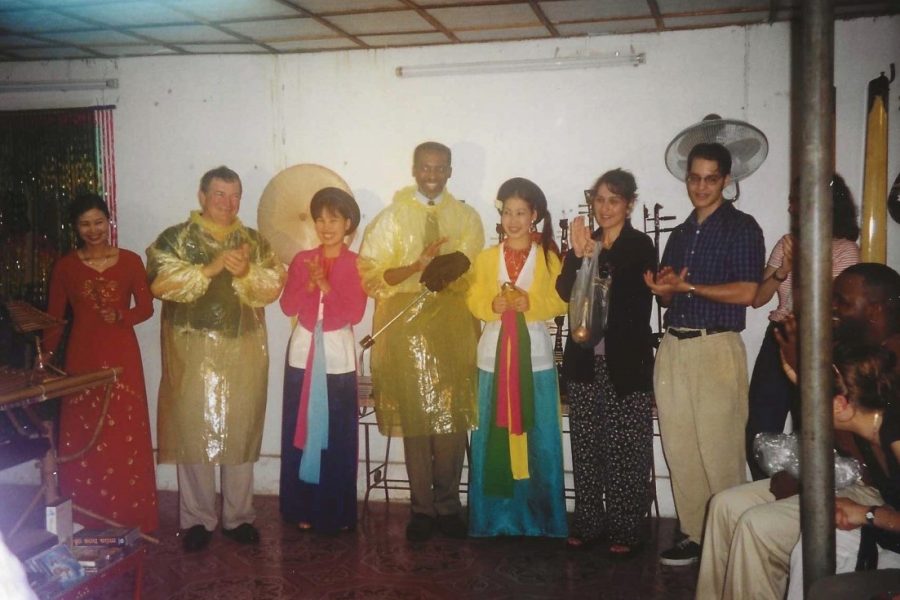 Jim Pitts (to the left wearing a yellow rain jacket) with André Thomas, former Owen F. Sellers Professor of Music in the College of Music and director of the University Singers (in the middle wearing a yellow rain jacket), and musicians in Vietnam during the University Singers' concert tour there in 1999. (International Programs)