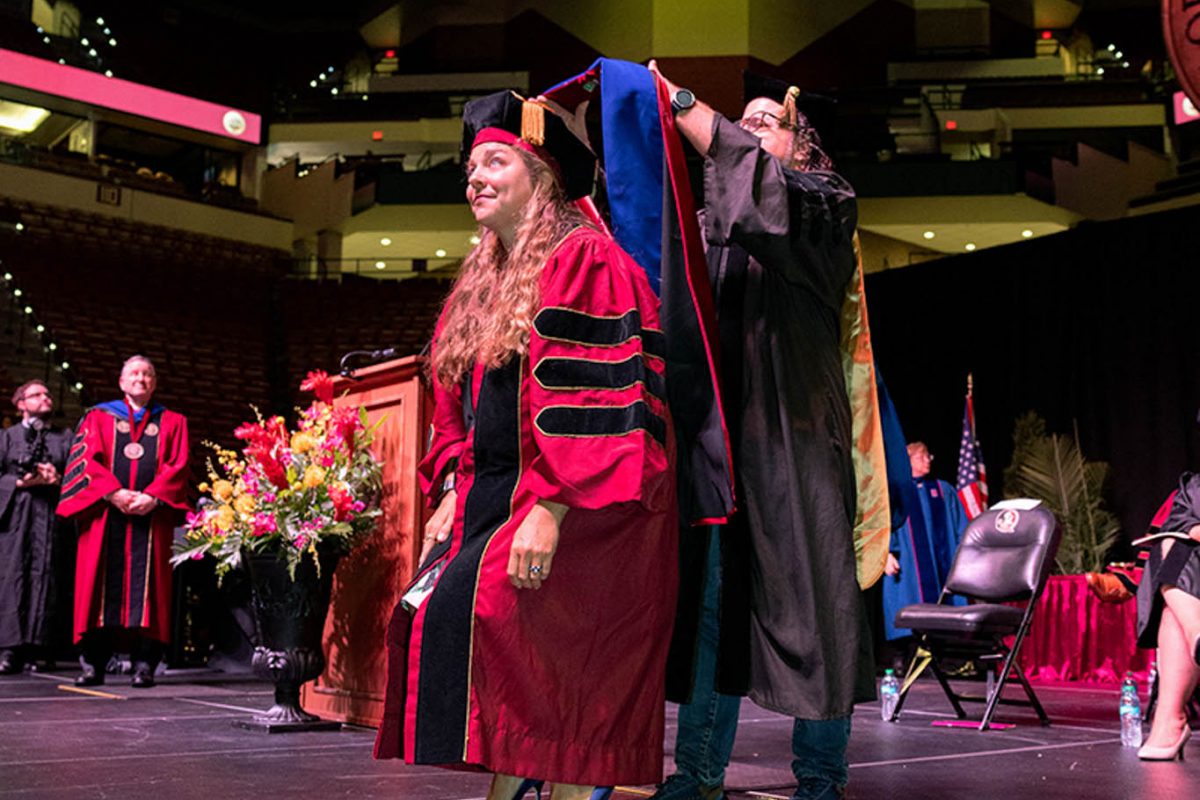 A Florida State University faculty member hoods a doctoral graduate at the summer doctoral hooding ceremony Friday, Aug. 2, 2024, at the Donald L. Tucker Civic Center. (FSU Photography)