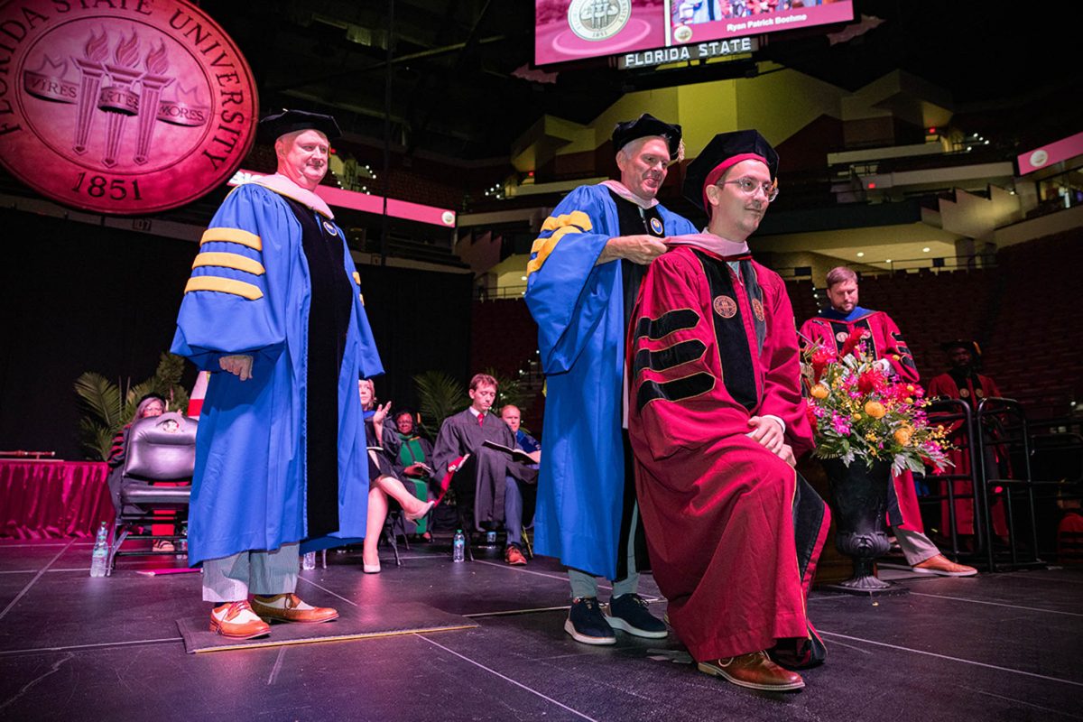 A Florida State University faculty member hoods a doctoral graduate at the summer doctoral hooding ceremony Friday, Aug. 2, 2024, at the Donald L. Tucker Civic Center. (FSU Photography)