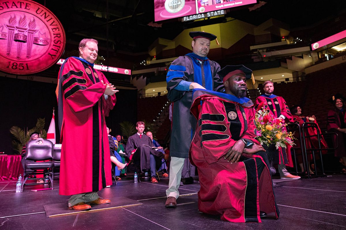 A Florida State University faculty member hoods a doctoral graduate at the summer doctoral hooding ceremony Friday, Aug. 2, 2024, at the Donald L. Tucker Civic Center. (FSU Photography)