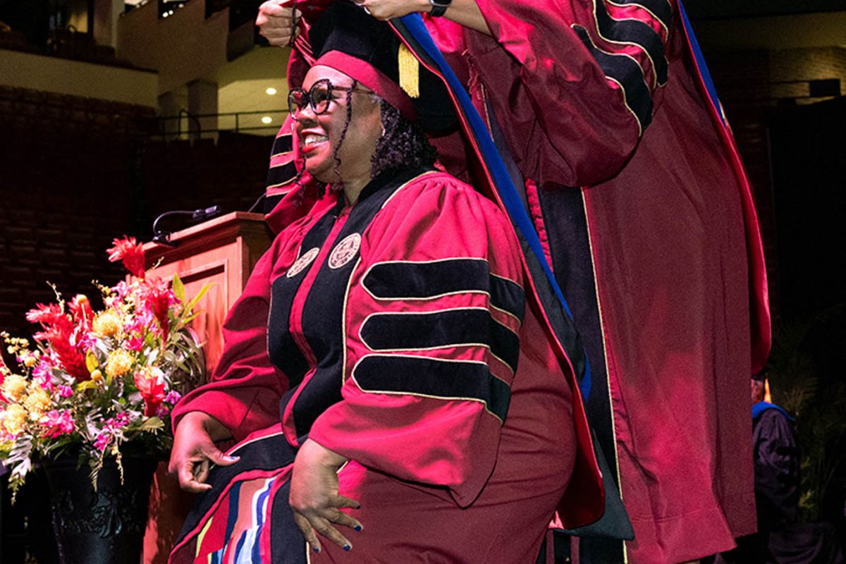 A Florida State University faculty member hoods a doctoral graduate at the summer doctoral hooding ceremony Friday, Aug. 2, 2024, at the Donald L. Tucker Civic Center. (FSU Photography)