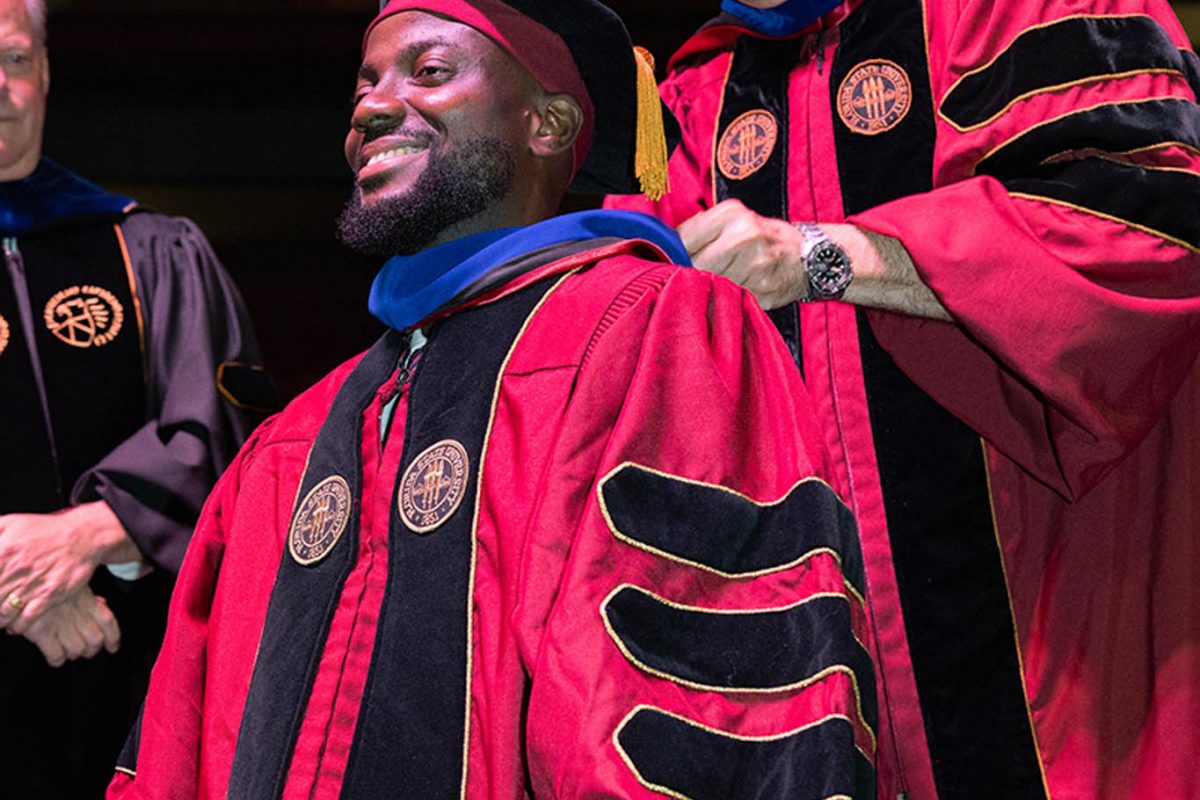 A Florida State University faculty member hoods a doctoral graduate at the summer doctoral hooding ceremony Friday, Aug. 2, 2024, at the Donald L. Tucker Civic Center. (FSU Photography)