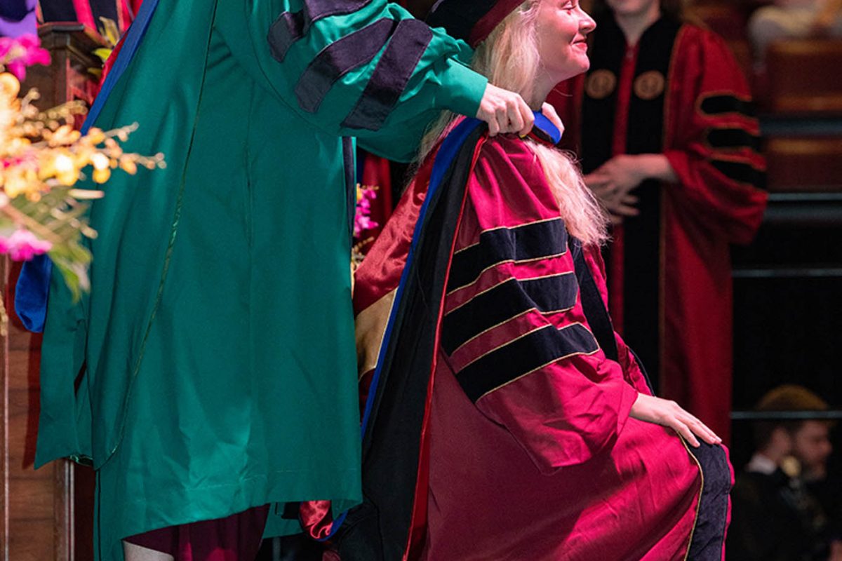 A Florida State University faculty member hoods a doctoral graduate at the summer doctoral hooding ceremony Friday, Aug. 2, 2024, at the Donald L. Tucker Civic Center. (FSU Photography)