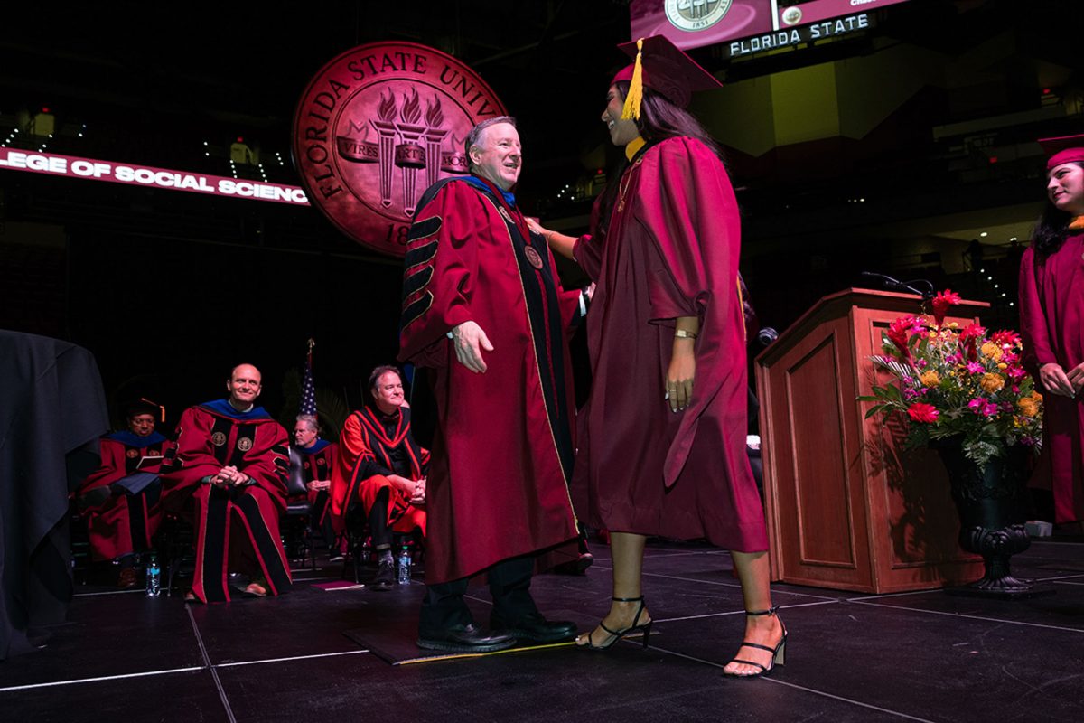 President Richard McCullough congratulates a graduate during one of FSU's summer commencement ceremonies Friday, Aug. 2, 2024, at the Donald L. Tucker Civic Center. (FSU Photography Services)