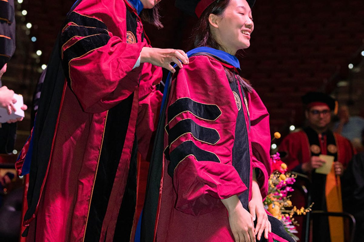 A Florida State University faculty member hoods a doctoral graduate at the summer doctoral hooding ceremony Friday, Aug. 2, 2024, at the Donald L. Tucker Civic Center. (FSU Photography)