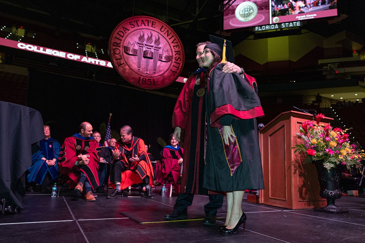 President Richard McCullough congratulates a graduate during one of FSU's summer commencement ceremonies Friday, Aug. 2, 2024, at the Donald L. Tucker Civic Center. (FSU Photography Services)