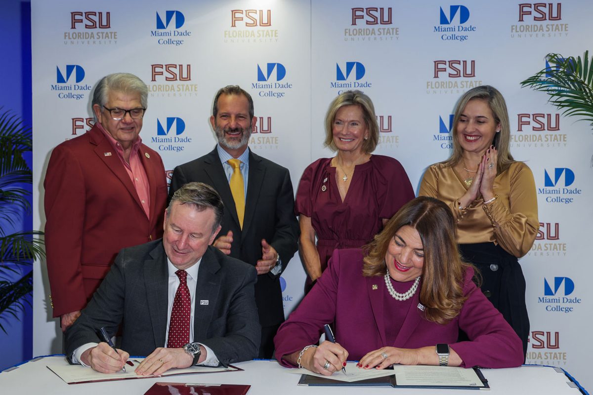 FSU President Richard McCullough and Miami Dade College President Madeline Pumariega sign an articlulation agreement to create clearer pathways and enhanced advising for MDC students to transfer to FSU. Also on hand for the signing Thursday in Miami, back row, left to right: FSU Trustee Max Alvarez, MDC Board Chairman Mike Bileca, and FSU Trustees Deborah Sargeant and Vivian de las Cuevas-Diaz. (Miami Dade College)