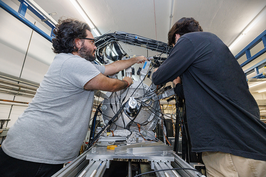 Florida State University graduate students Chris Esparza and Matthew Mestayer working on the Array for Nuclear Astrophysics and Structure with Exotic Nuclei, or ANASEN, an active target detector in the John D. Fox Superconducting Linear Accelerator Laboratory. (Bill Lax/FSU Photography Services)