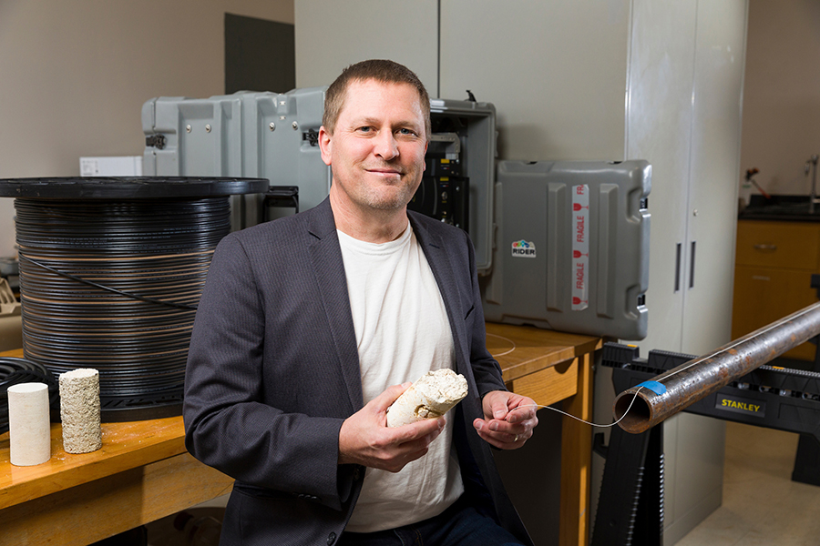 Scott Wasman, Ph.D., assistant professor of Civil and Environmental Engineering, poses with fiber optic equipment and limestone core samples. (Scott Holstein/FAMU-FSU College of Engineering)