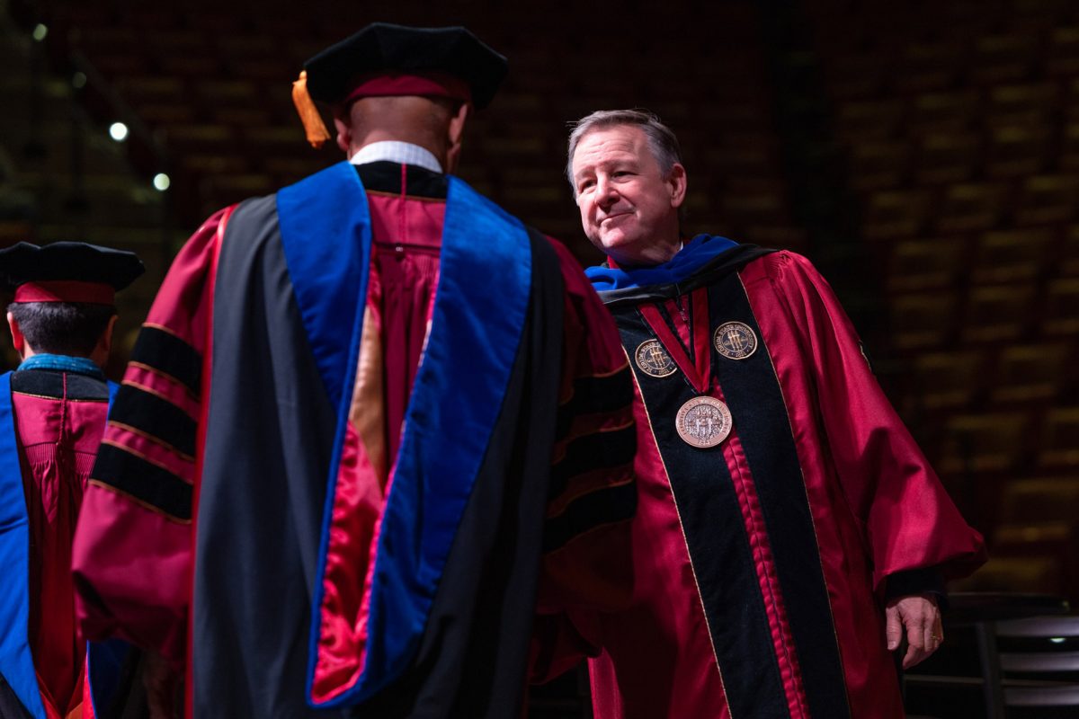 Florida State University President Richard McCullough congratulates a graduate during the university’s fall doctoral hooding ceremony Friday, Dec. 13, 2024, at the Donald L. Tucker Civic Center. (FSU Photography)