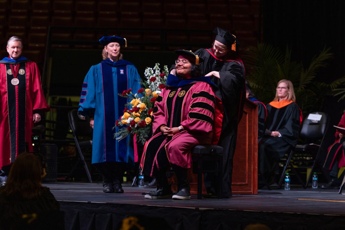 A Florida State University faculty member hoods a graduate during the fall doctoral hooding ceremony Friday, Dec. 13, 2024, at the Donald L. Tucker Civic Center. (FSU Photography)