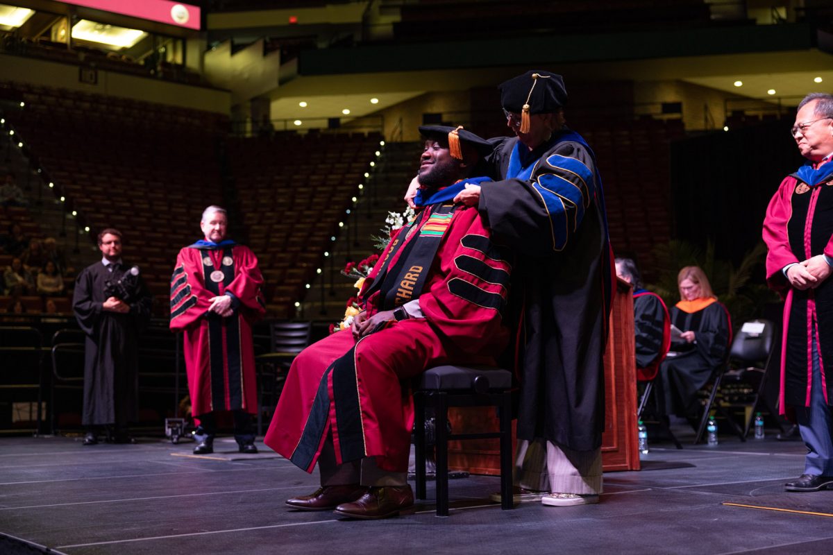 A Florida State University faculty member hoods a graduate during the fall doctoral hooding ceremony Friday, Dec. 13, 2024, at the Donald L. Tucker Civic Center. (FSU Photography)