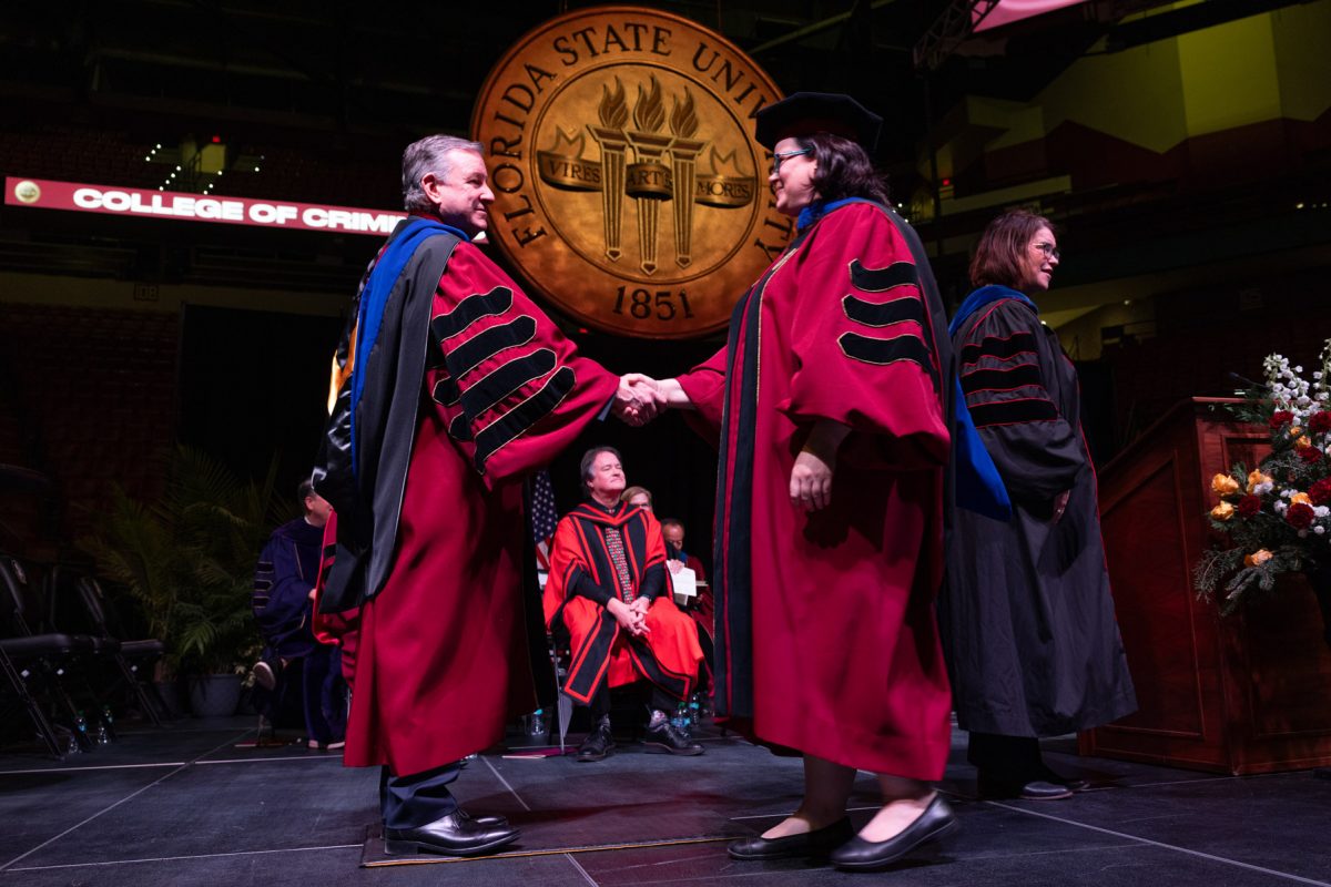 Florida State University President Richard McCullough shakes hands with a graduate during the fall doctoral hooding ceremony Friday, Dec. 13, 2024, at the Donald L. Tucker Civic Center. (FSU Photography)