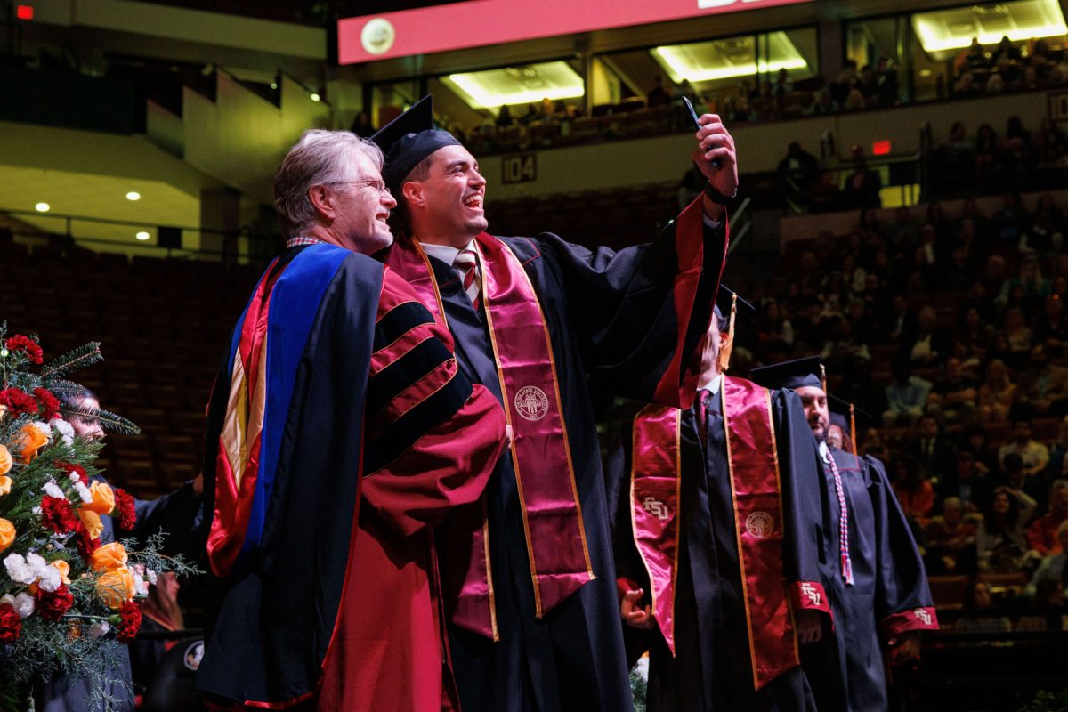 A graduate poses for a selfie on stage during one of FSU's fall commencement ceremonies Friday, Dec. 13, 2024, at the Donald L. Tucker Civic Center. (FSU Photography)