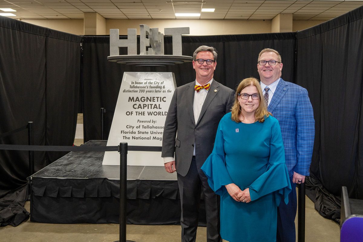 From left, Tallahassee Mayor John Dailey, FSU Senior Vice President for Finance and Administration Kyle Clark, and Director of the National High Magnetic Field Laboratory Kathleen Amm stand in front of “Maggie.” (Courtesy of the National High Magnetic Field Laboratory)