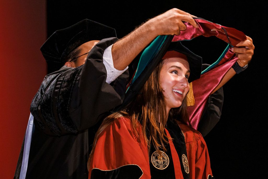 Tallahassee Regional Campus Dean, Dr. Sandeep Rahangdale, hoods Rachel Cervera during Saturday’s M.D. Class of 2025 commencement ceremony.