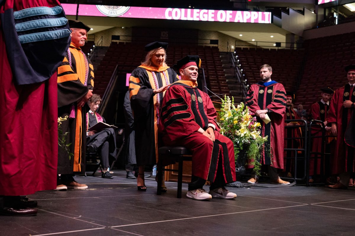 A Florida State University faculty member hoods a graduate during the spring doctoral hooding ceremony Friday, May 2, 2025, at the Donald L. Tucker Civic Center. (FSU Photography)