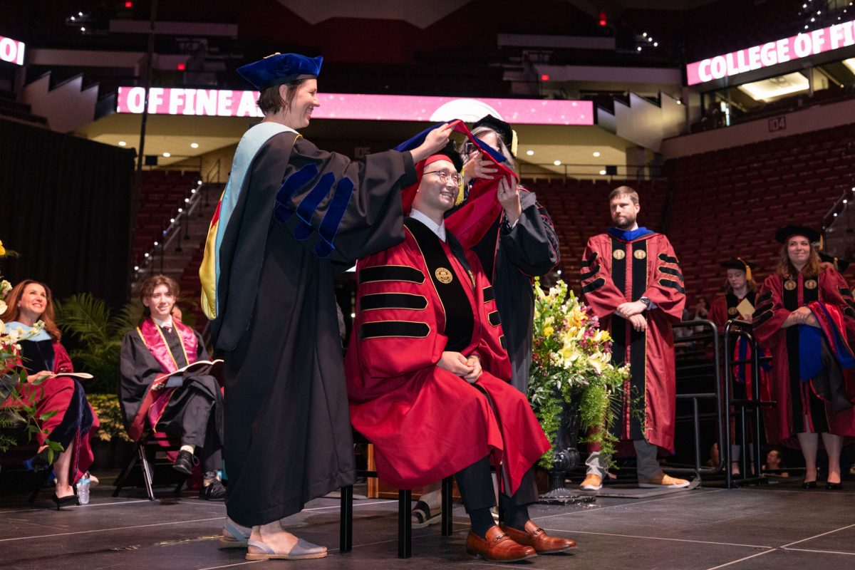 Two Florida State University faculty members hood a graduate during the spring doctoral hooding ceremony Friday, May 2, 2025, at the Donald L. Tucker Civic Center. (FSU Photography)