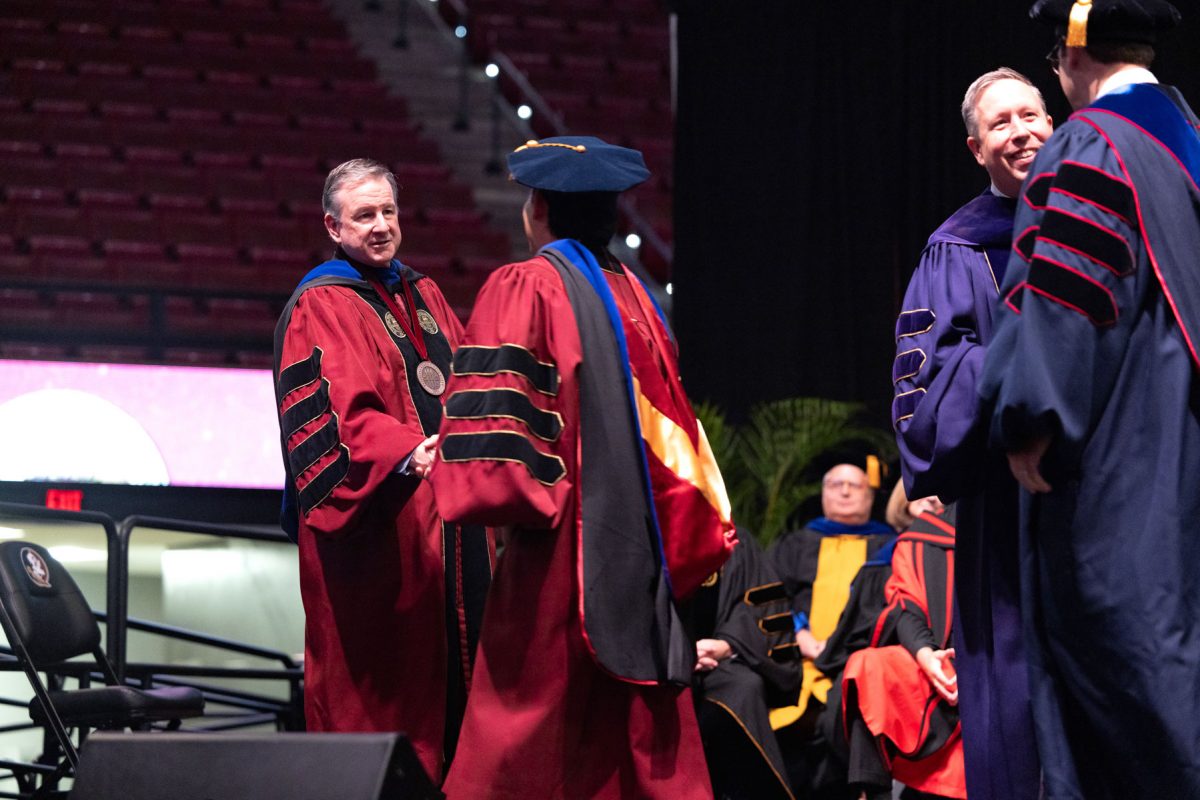 Florida State University President Richard McCullough congratulates a graduate at the university’s spring doctoral hooding ceremony Friday, May 2, 2025, at the Donald L. Tucker Civic Center. (FSU Photography)