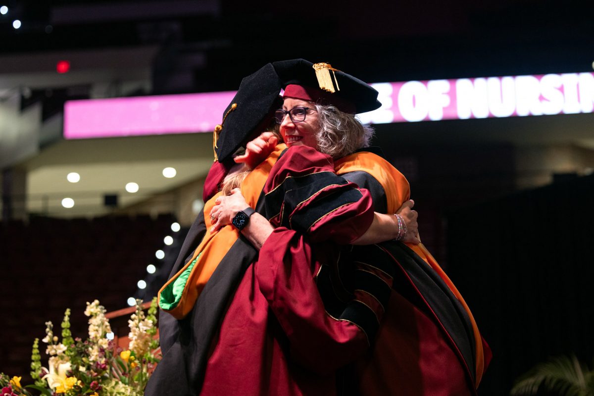 A Florida State University faculty member hugs a graduate during the spring doctoral hooding ceremony Friday, May 2, 2025, at the Donald L. Tucker Civic Center. (FSU Photography)