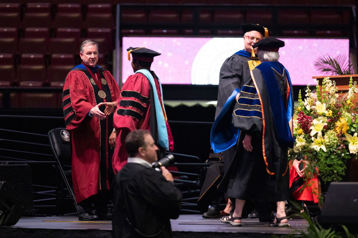 Florida State University President Richard McCullough congratulates a graduate at the university’s spring doctoral hooding ceremony Friday, May 2, 2025, at the Donald L. Tucker Civic Center. (FSU Photography)