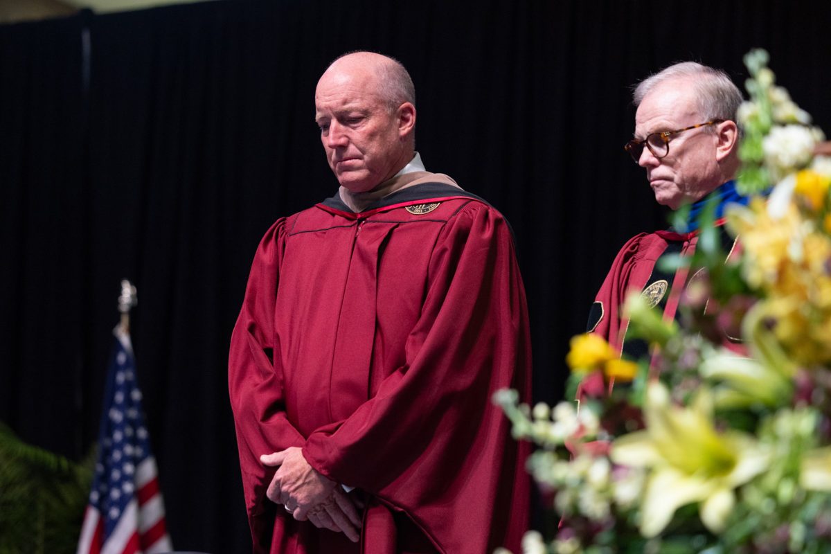 Florida State University Board of Trustees Chairman Peter Collins and Vice Chair for J.P. Morgan Asset Management Ash Williams during a moment of silence for the April 17 shooting victims, at one of the university's spring ceremonies Friday, May 2, 2025, at the Donald L. Tucker Civic Center. (FSU Photography Services)