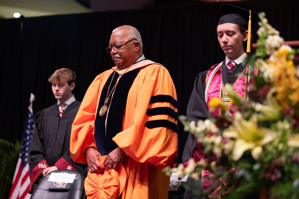 2025-2026 Student Body President Carson Dale, former FSU College of Business Dean Mel Stith, and 2024-2025 Student Body President Jackson Boisvert during a moment of silence for the April 17 shooting victims, at one of the university's spring ceremonies Saturday, May 3, 2025, at the Donald L. Tucker Civic Center. (FSU Photography Services)