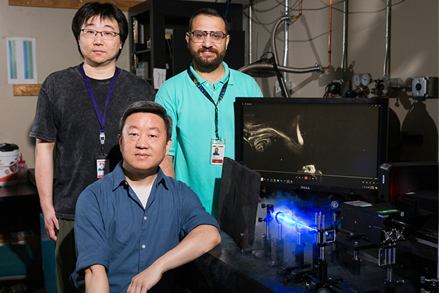 From left, postdoctoral researcher Yiming Xing, Professor Wei Guo, and graduate student Yousef Alihosseini at the National High Magnetic Field Laboratory. The researchers injected tiny frozen particles into superfluid helium to make invisible quantum vortices visible. They then used a laser sheet and a high-speed camera to capture how these vortices moved and reconnected. (Scott Holstein/FAMU-FSU College of Engineering)